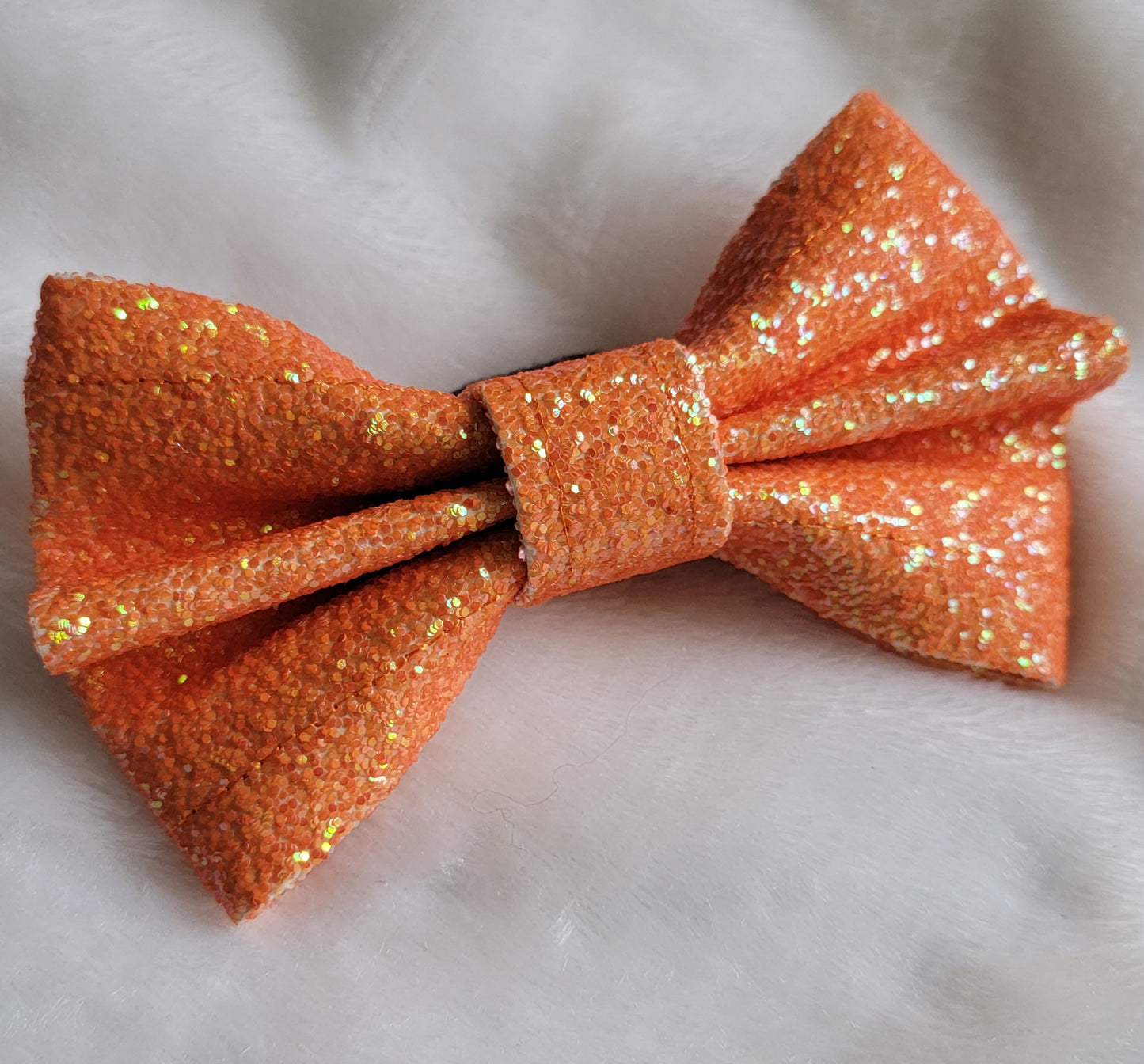 Bright pumpkin orange glitter canvas bow.