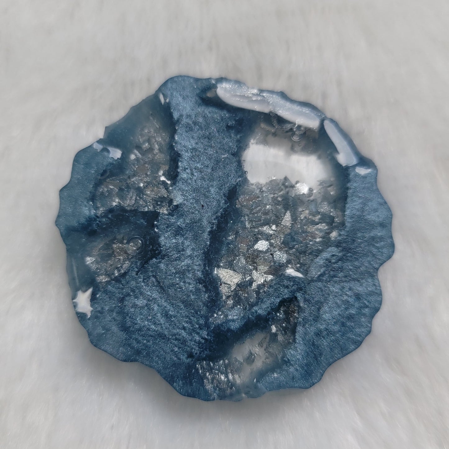 Irregular round epoxy resin piece made with ice blue mica pigment and silver crystalline texture insets throughout the piece.