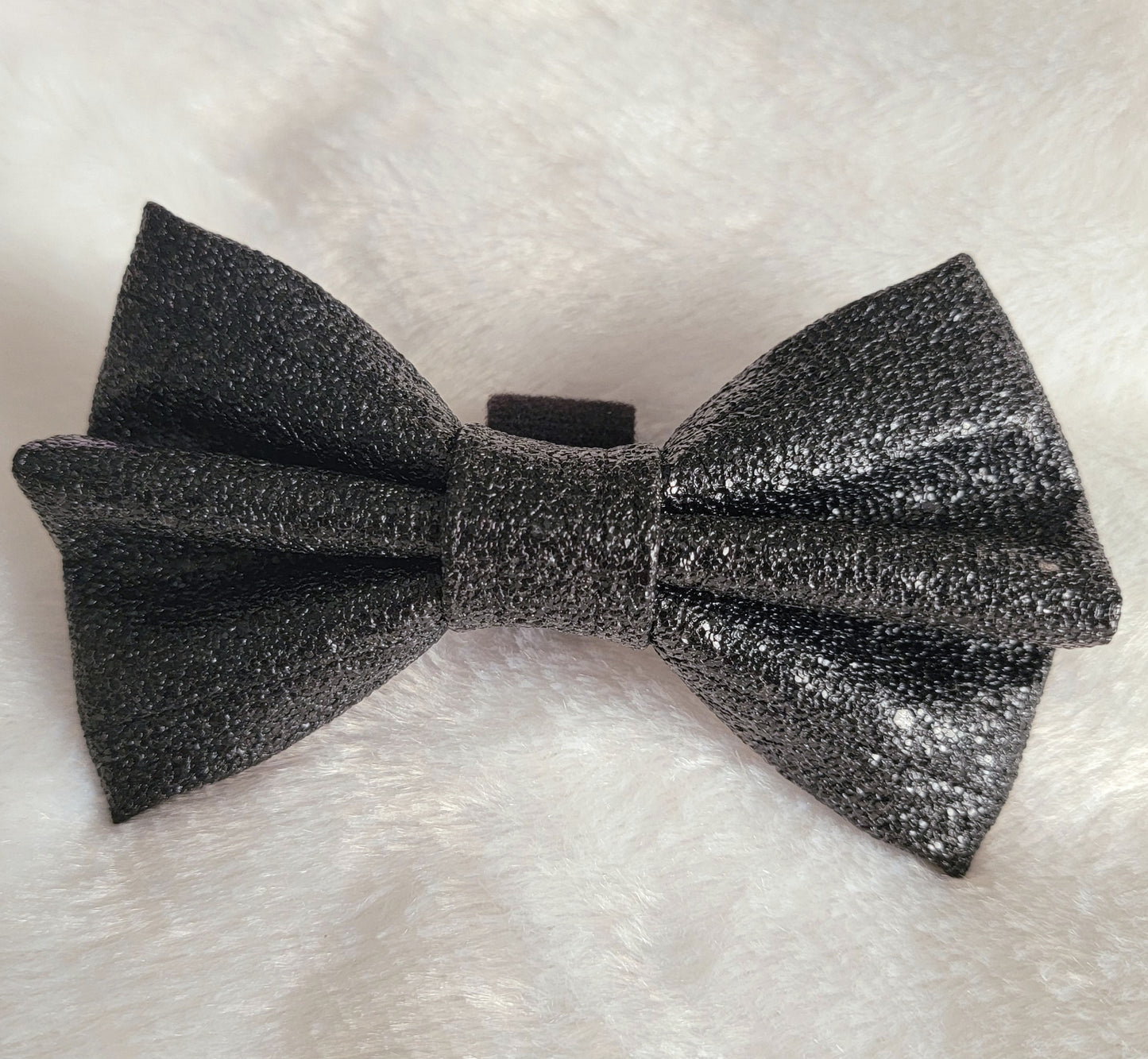 Black faux leather bow with sparkle texture.