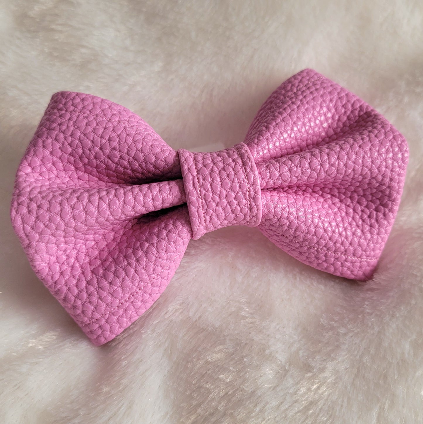 Pink colored with natural texture faux leather bowtie.