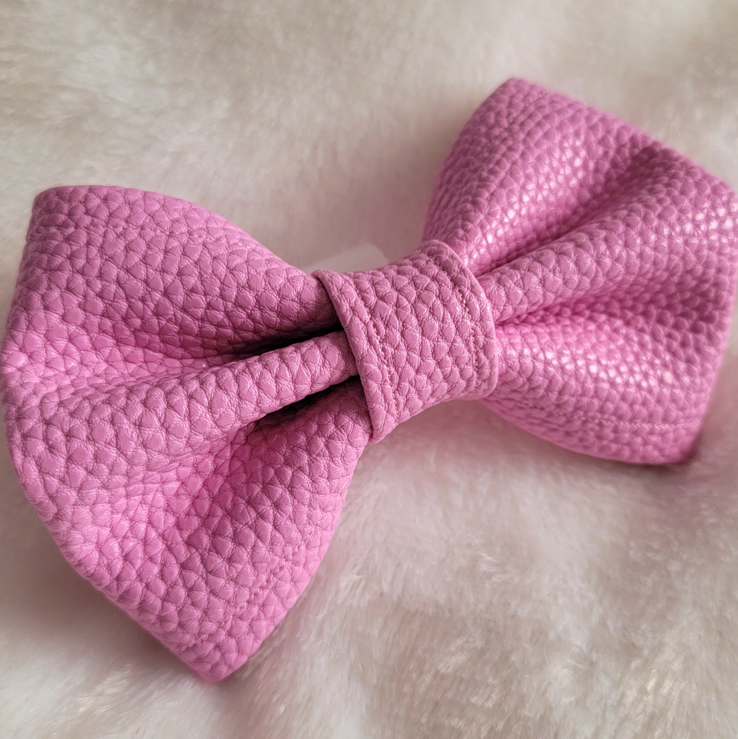 Pink colored with natural texture faux leather bowtie.