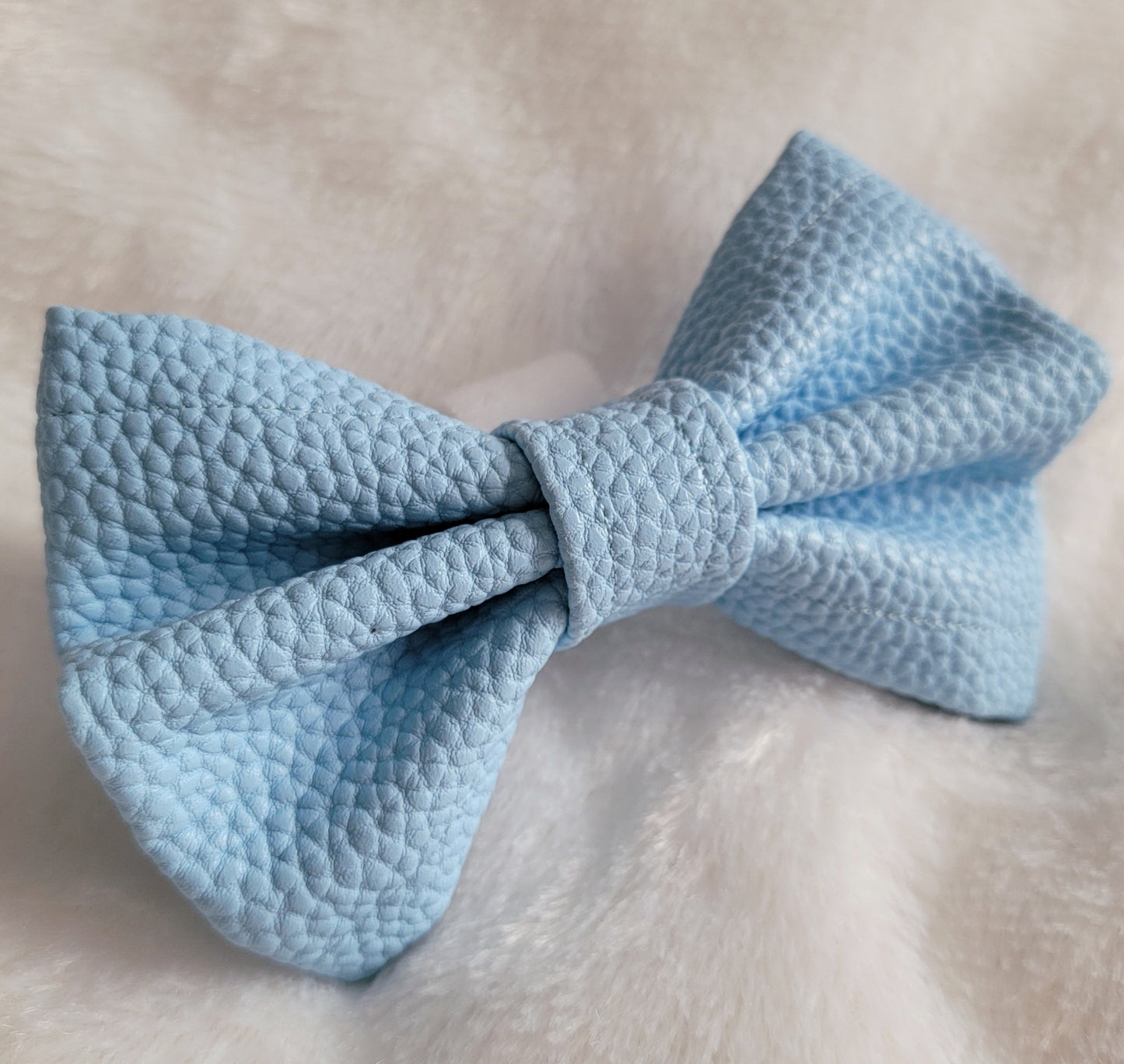 Light blue colored with natural texture faux leather bowtie.