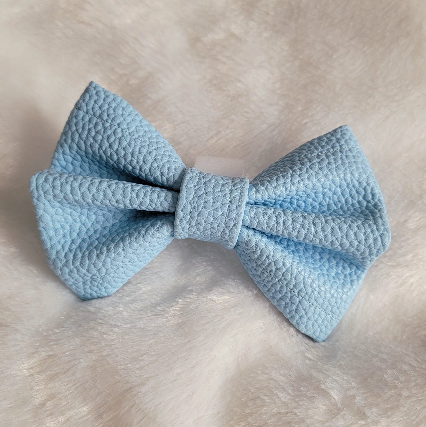 Light blue colored with natural texture faux leather bowtie.