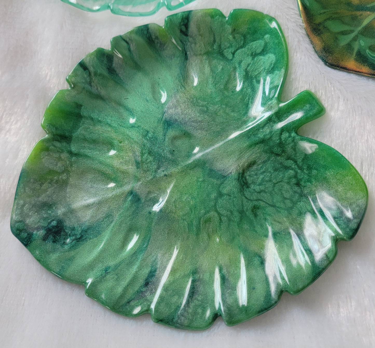 Monstera leaf shaped decorative dish made from epoxy resin, marbled shades of green.