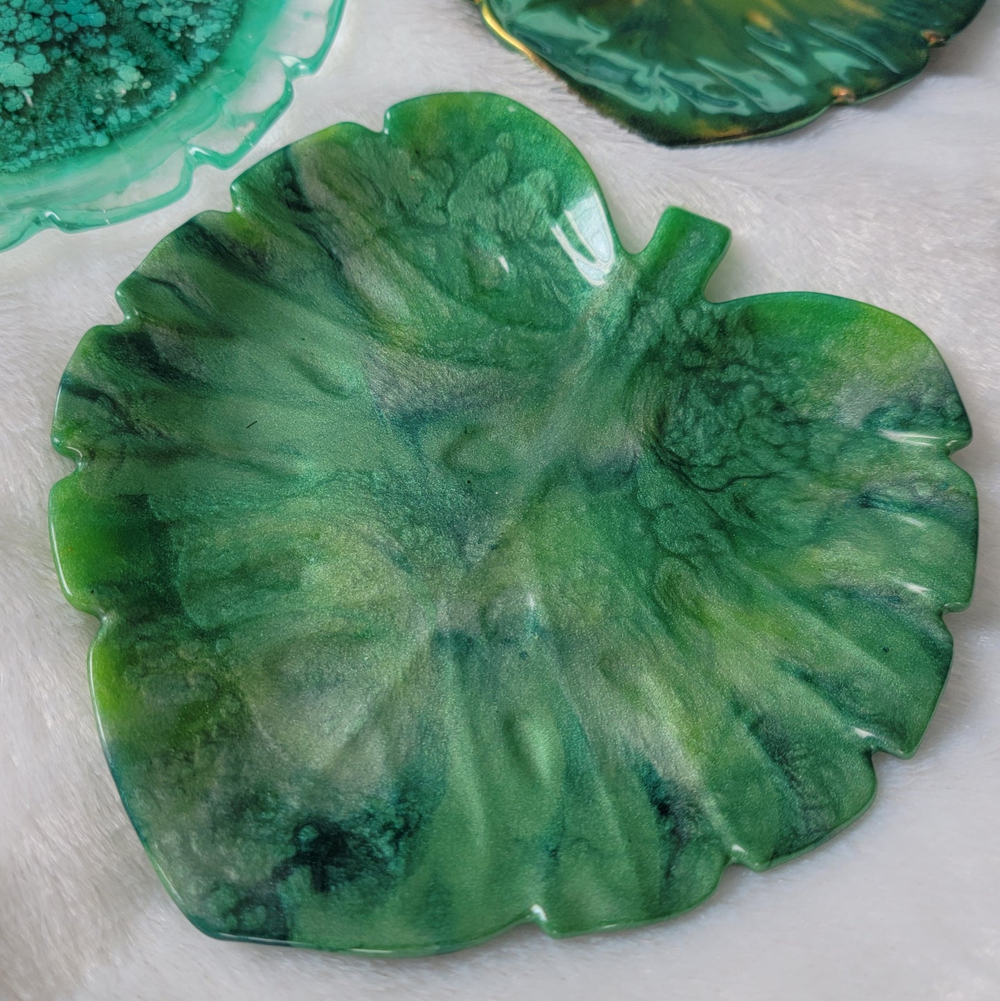 Monstera leaf shaped decorative dish made from epoxy resin, marbled shades of green.