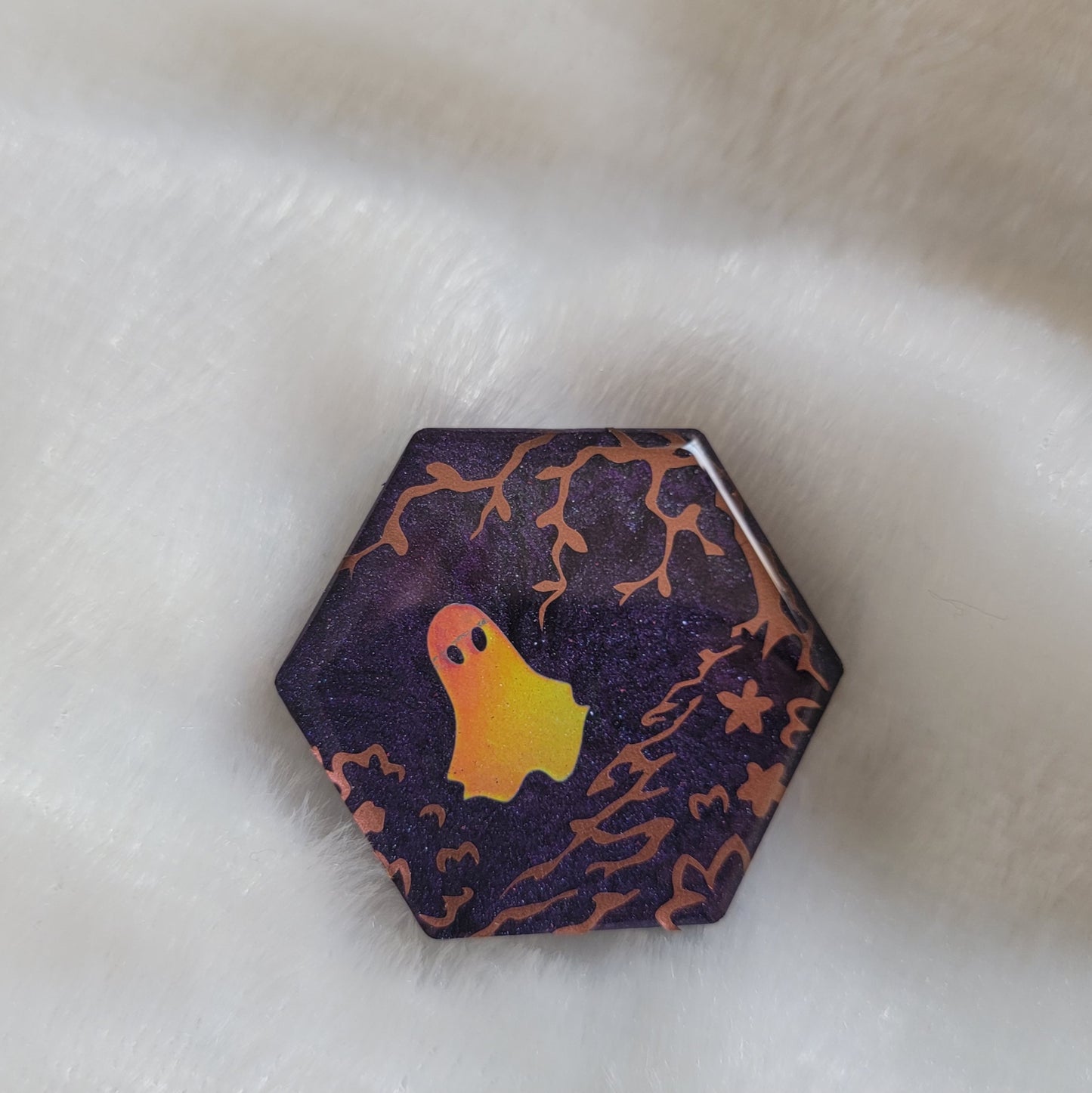 Dark purple hexagon shaped epoxy resin piece with a small scene of a ghost in a garden pathway made from copper and holographic vinyl, displayed on a white surface.