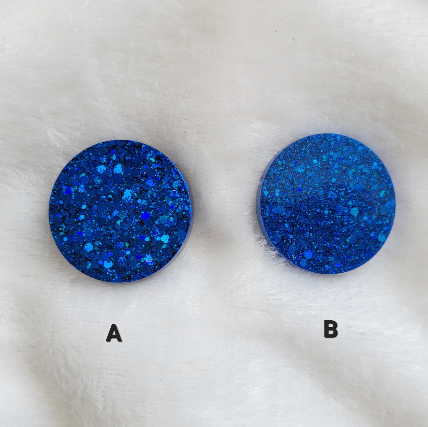 Two round epoxy resin pieces showing two color options - on the right blue glitter only, on the left blue glitter mixed with blue mica pigment,