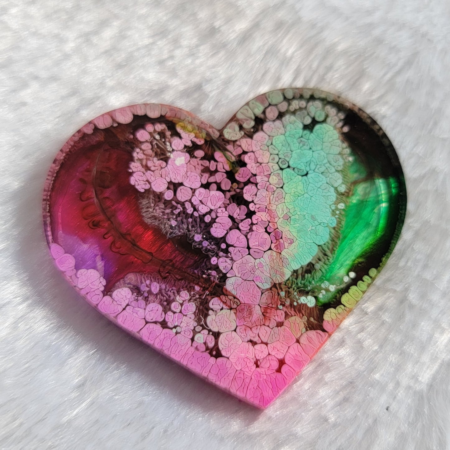 Heart shaped epoxy resin piece made with multicolored alcohol inks.