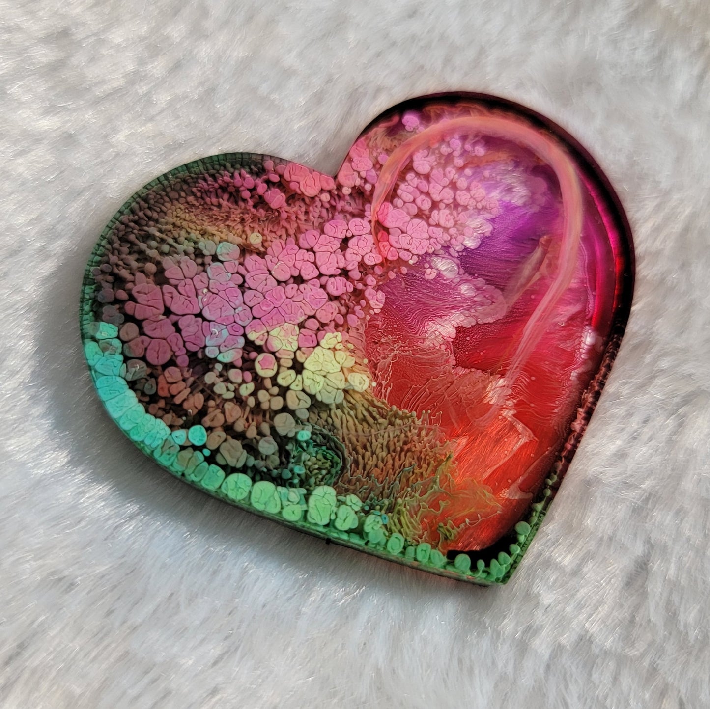 Heart shaped epoxy resin piece made with multicolored alcohol inks.