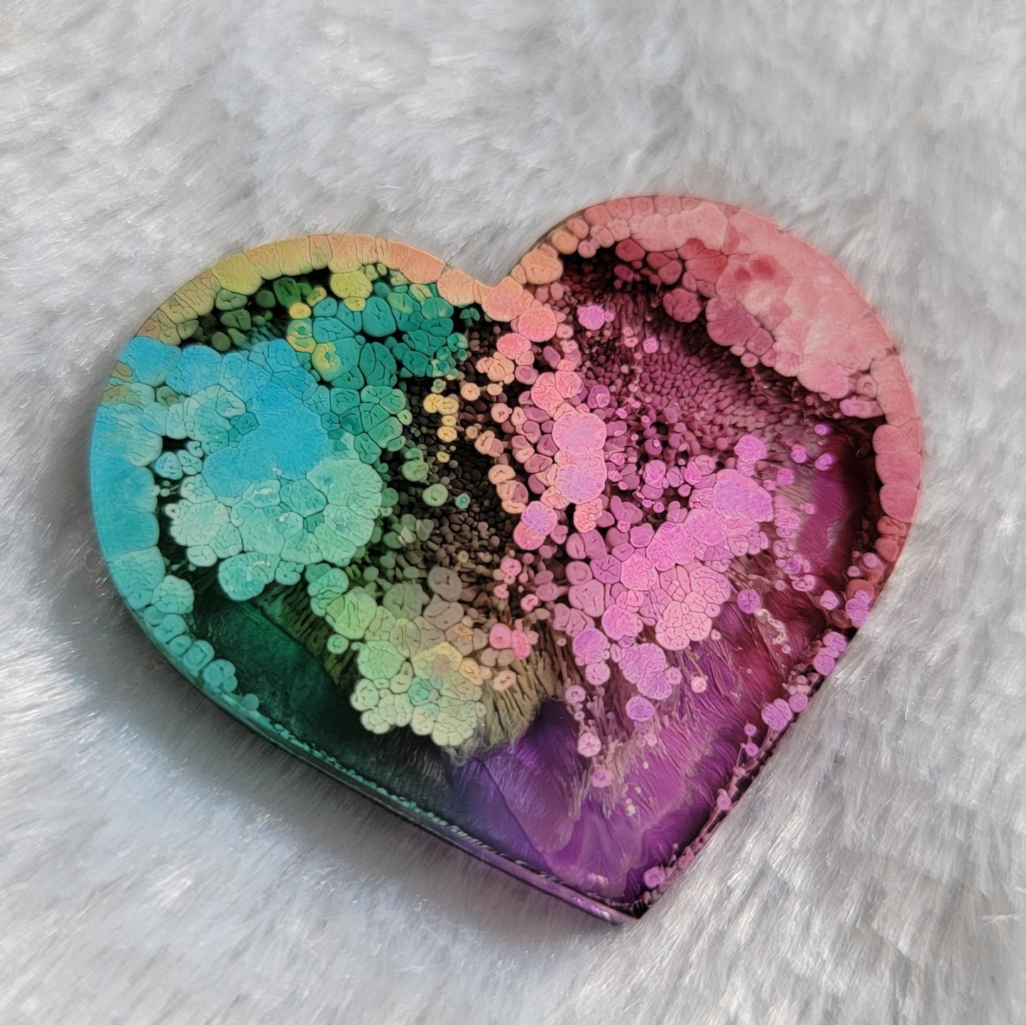 Heart shaped epoxy resin piece made with multicolored alcohol inks.