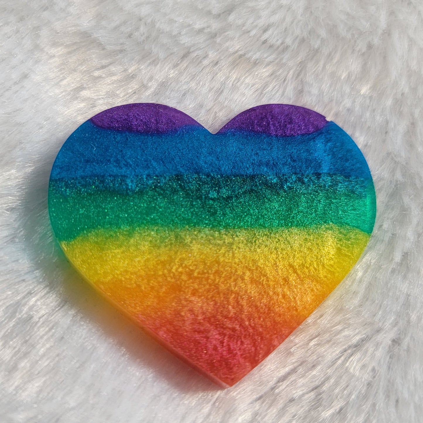 Heart shaped epoxy resin piece with horizontal rainbow stripes in shimmering mica pigments.