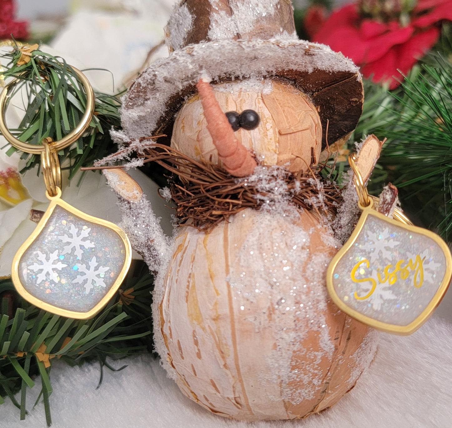 Small metal charm with white glittery snowflake epoxy resin filler, shown with snowman ornament and personalized version of the same charm.