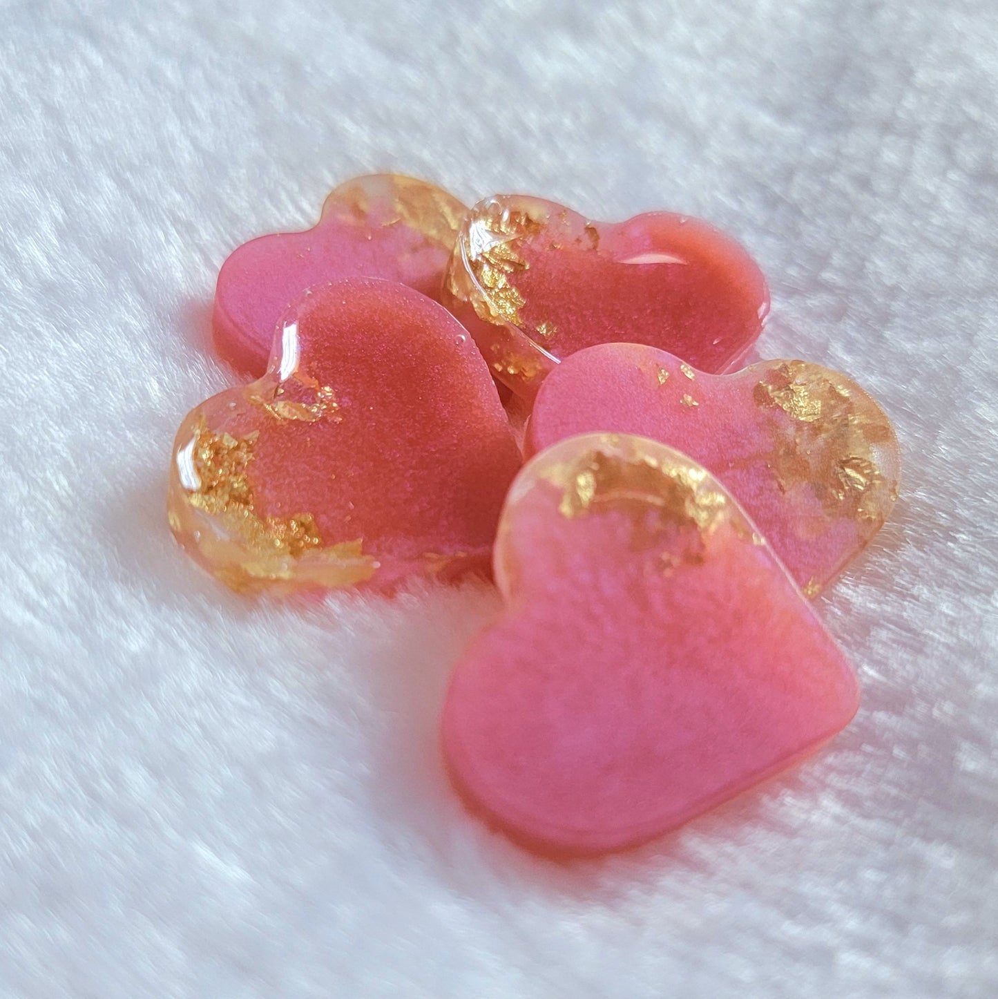 Mini heart shaped epoxy resin pieces, light pink shimmery pigment with gold foil flakes.