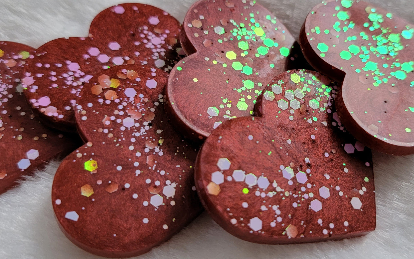 Heart shaped epoxy resin pieces, deep candy red pigment with opal white iridescent glitter.