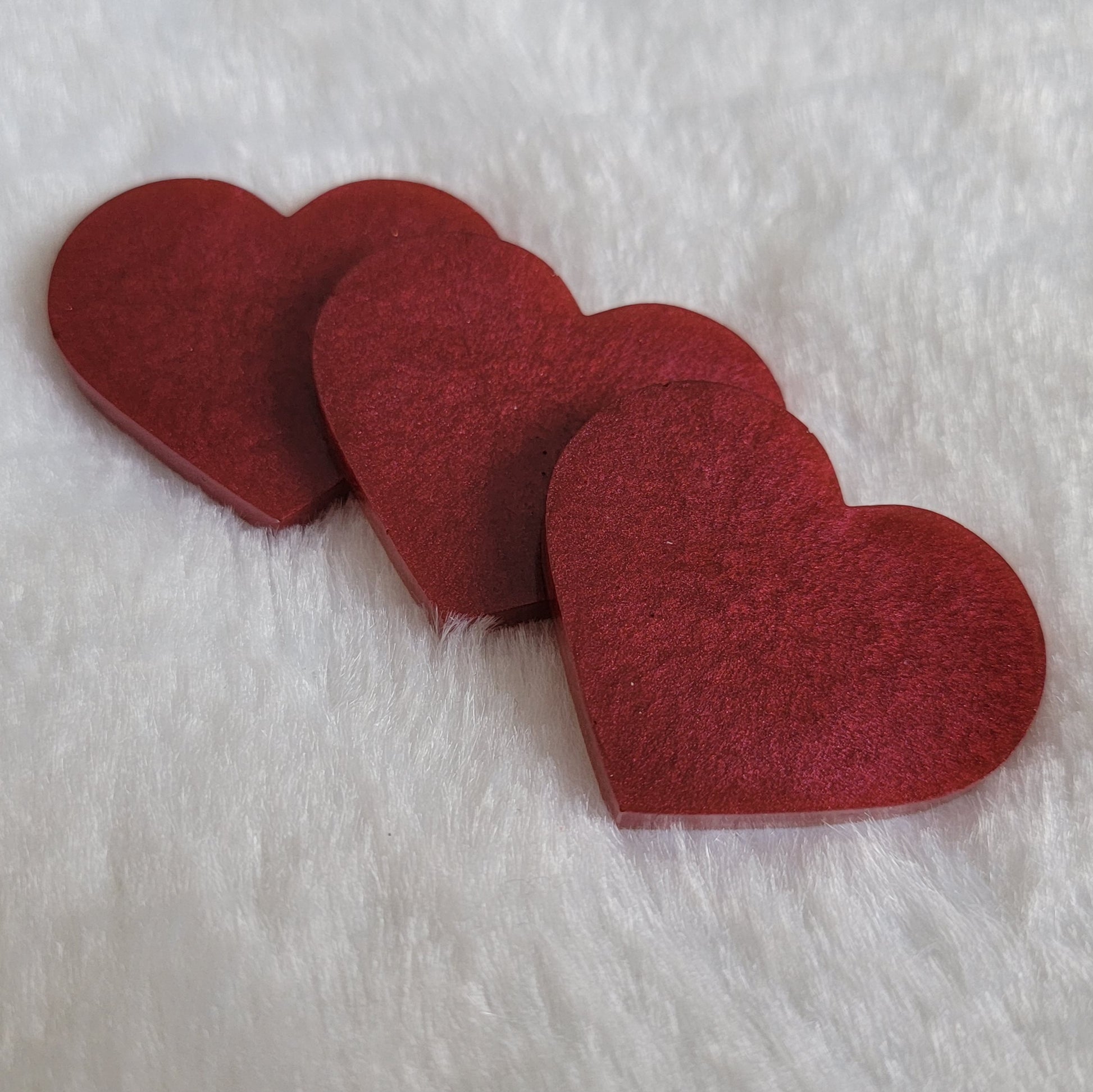 Heart shaped epoxy resin pieces, shiny deep wine red pigment.