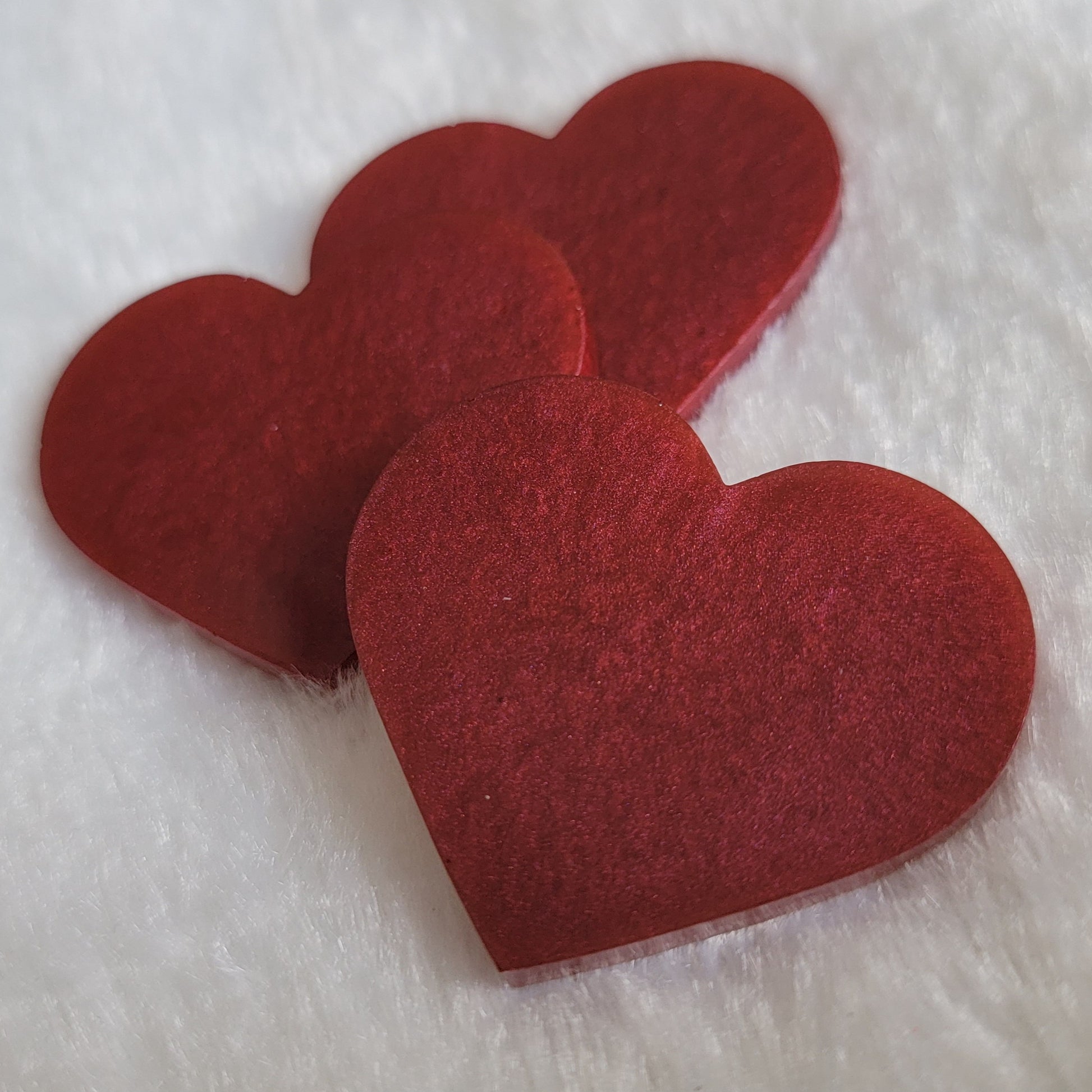 Heart shaped epoxy resin pieces, shiny deep wine red pigment.