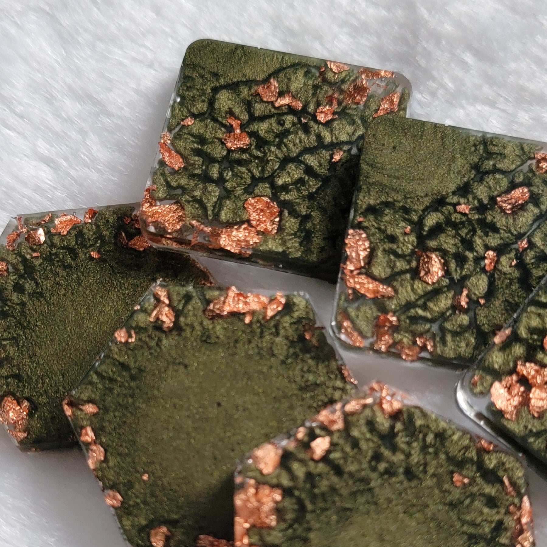 Square and hexagon shaped epoxy resin pieces, deep earthy green pigment marbled with copper foil flakes.