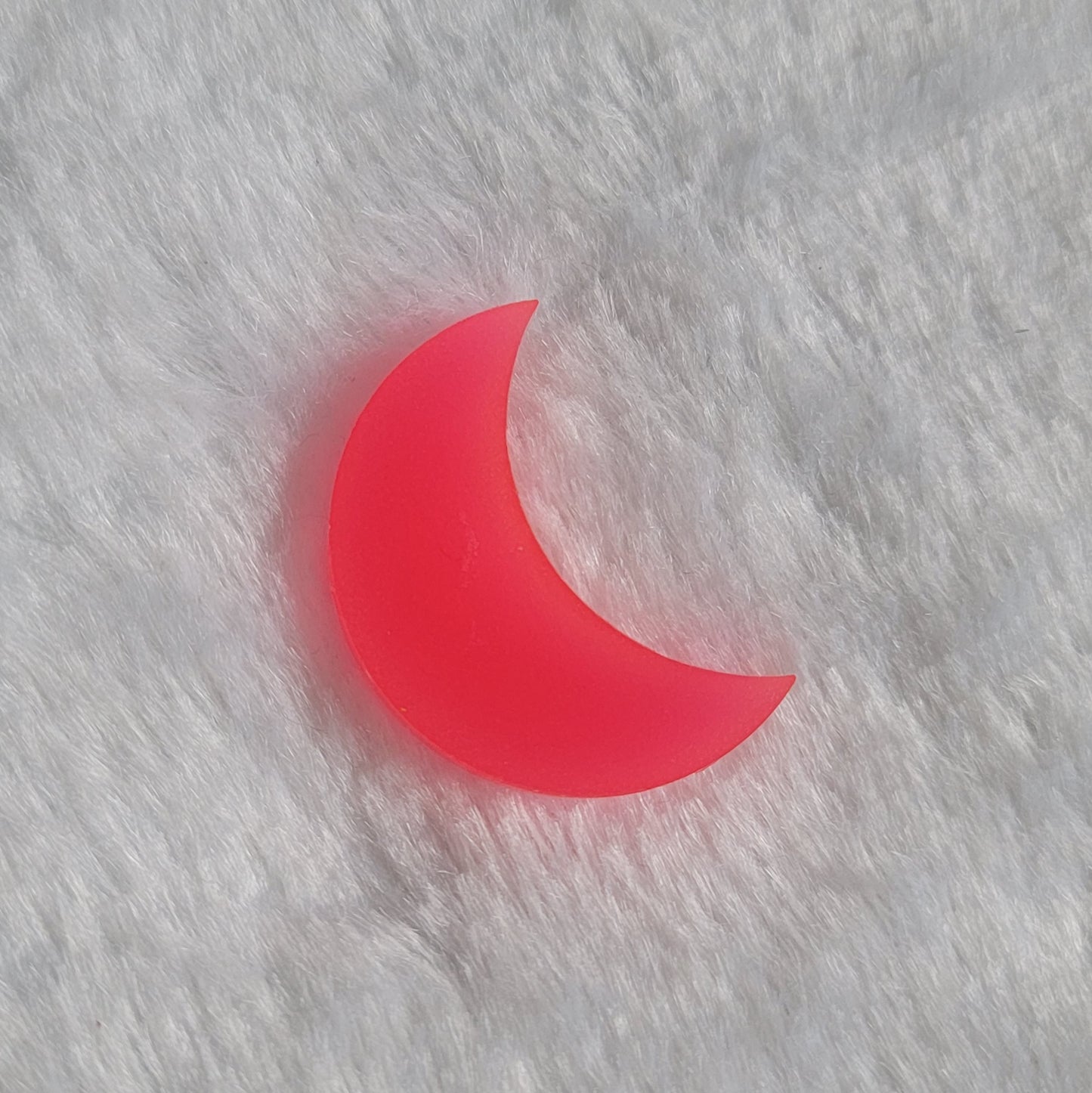 Crescent moon shaped epoxy resin piece, bright coral pink glow in the dark/UV reactive pigment.