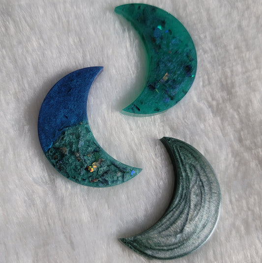 Three crescent moon shaped epoxy resin pieces, shades of blue.