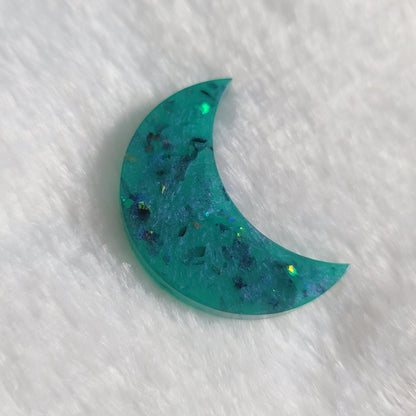 Crescent moon shaped epoxy resin piece, aqua blue with iridescent shard glitter.