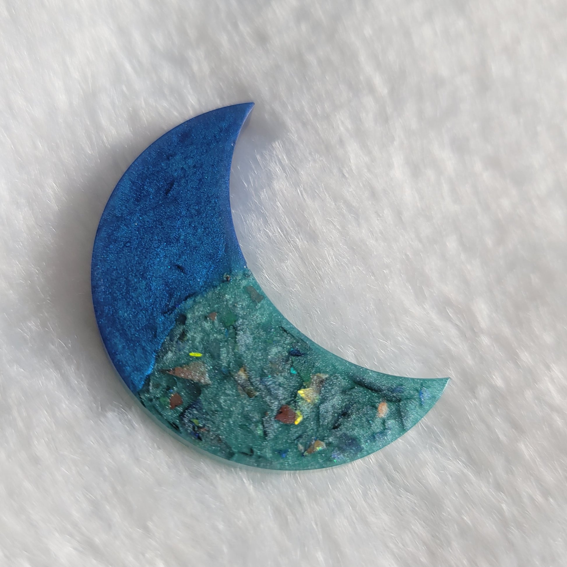 Crescent moon shaped epoxy resin piece, two tone blue with iridescent shard glitter.