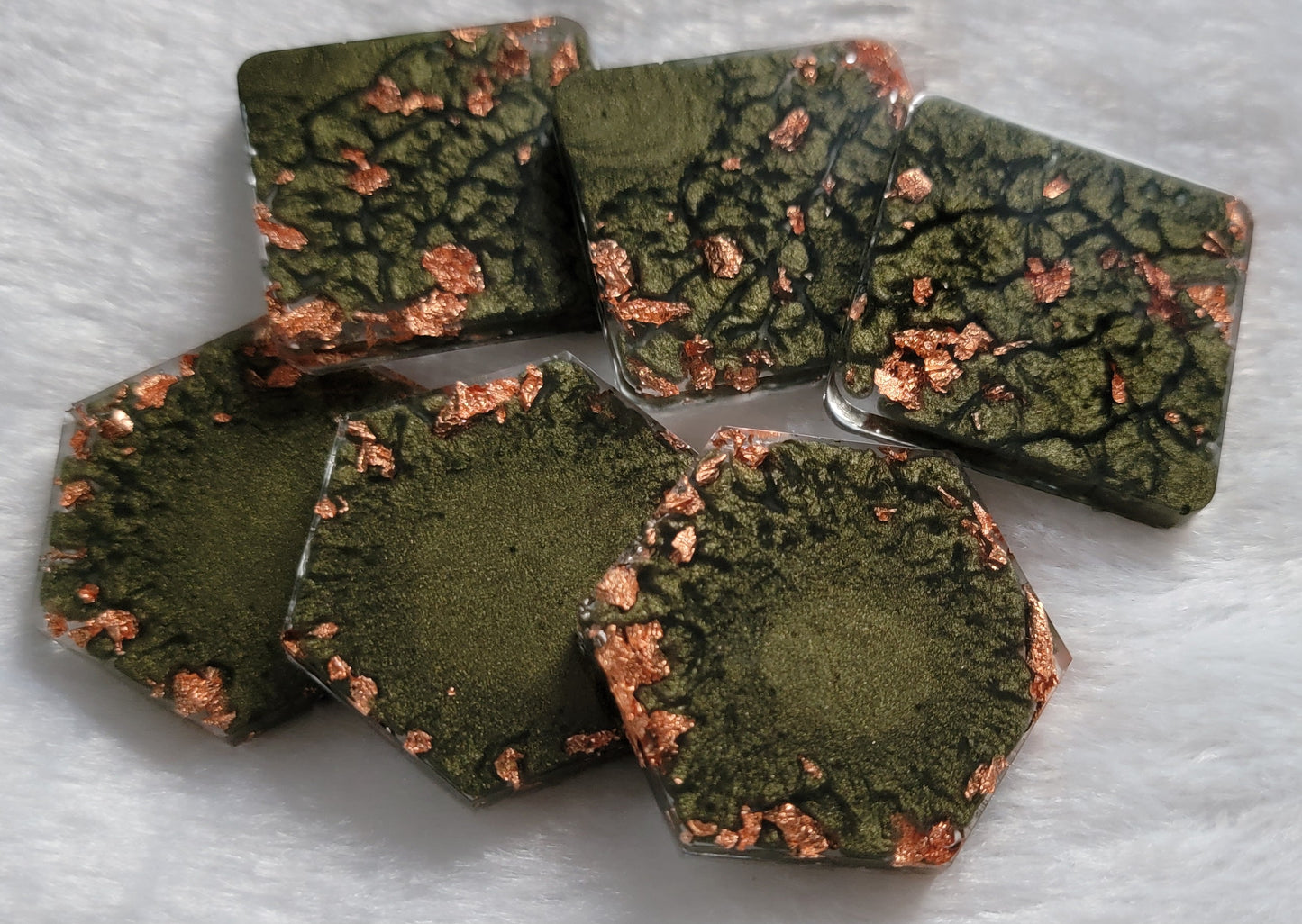 Square and hexagon shaped epoxy resin pieces, deep earthy green pigment marbled with copper foil flakes.