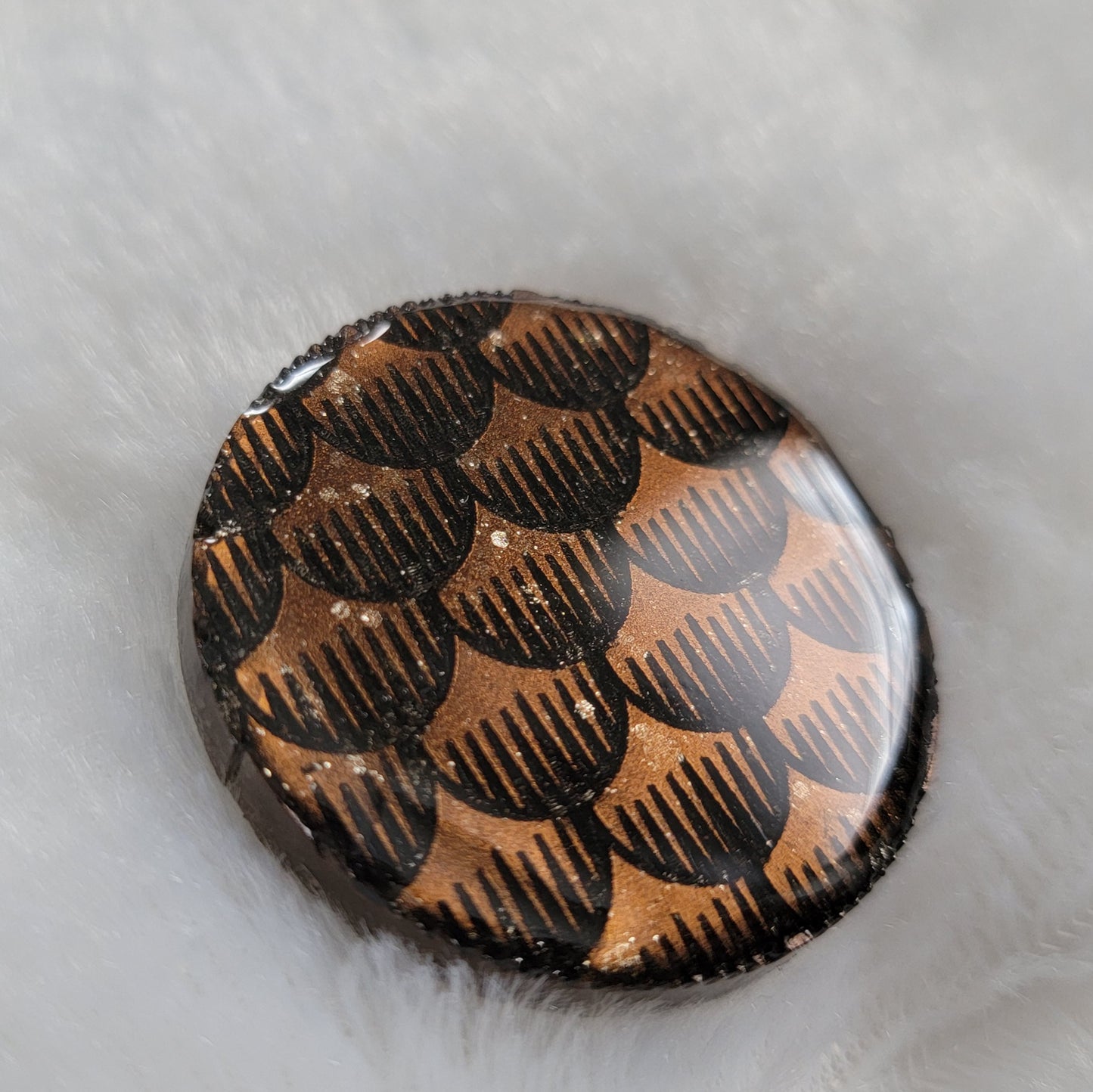 Round epoxy resin piece with cocoa brown metallic fish scales design.