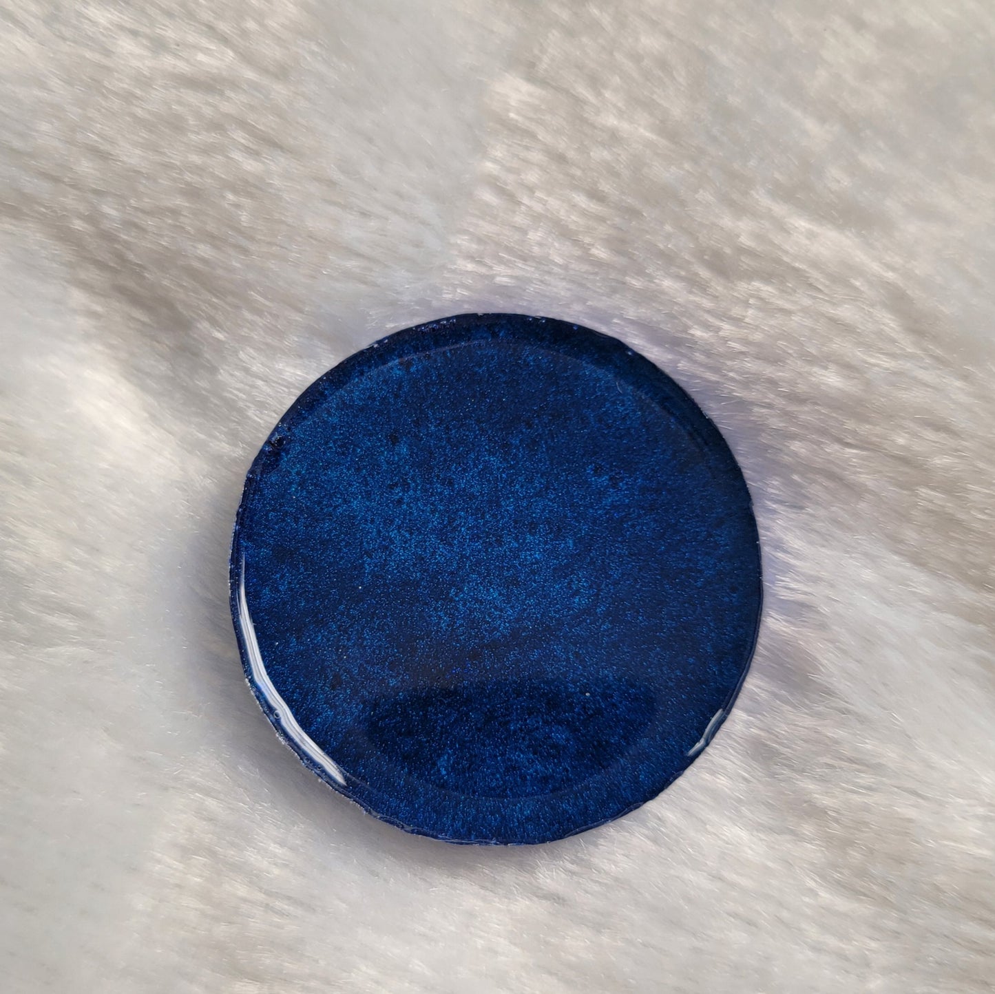 Round epoxy resin piece, dark blue back side.