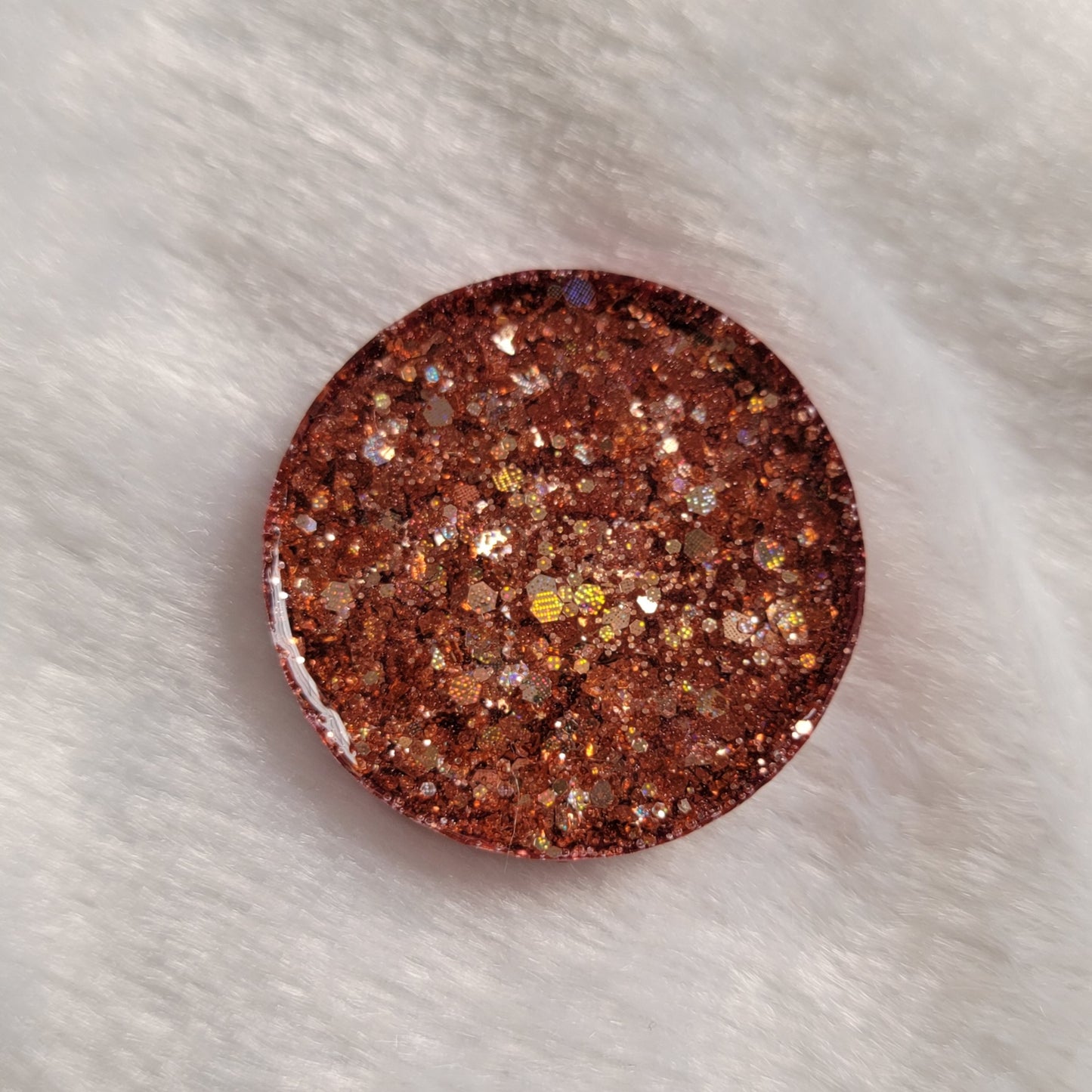 Round epoxy resin piece, rosy pink glitter back side.