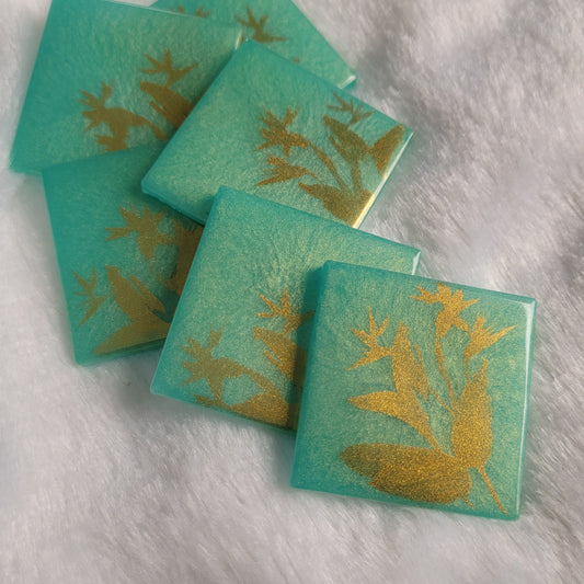 Square epoxy resin pieces, bright aqua green with gold chrome bird of paradise plant design.