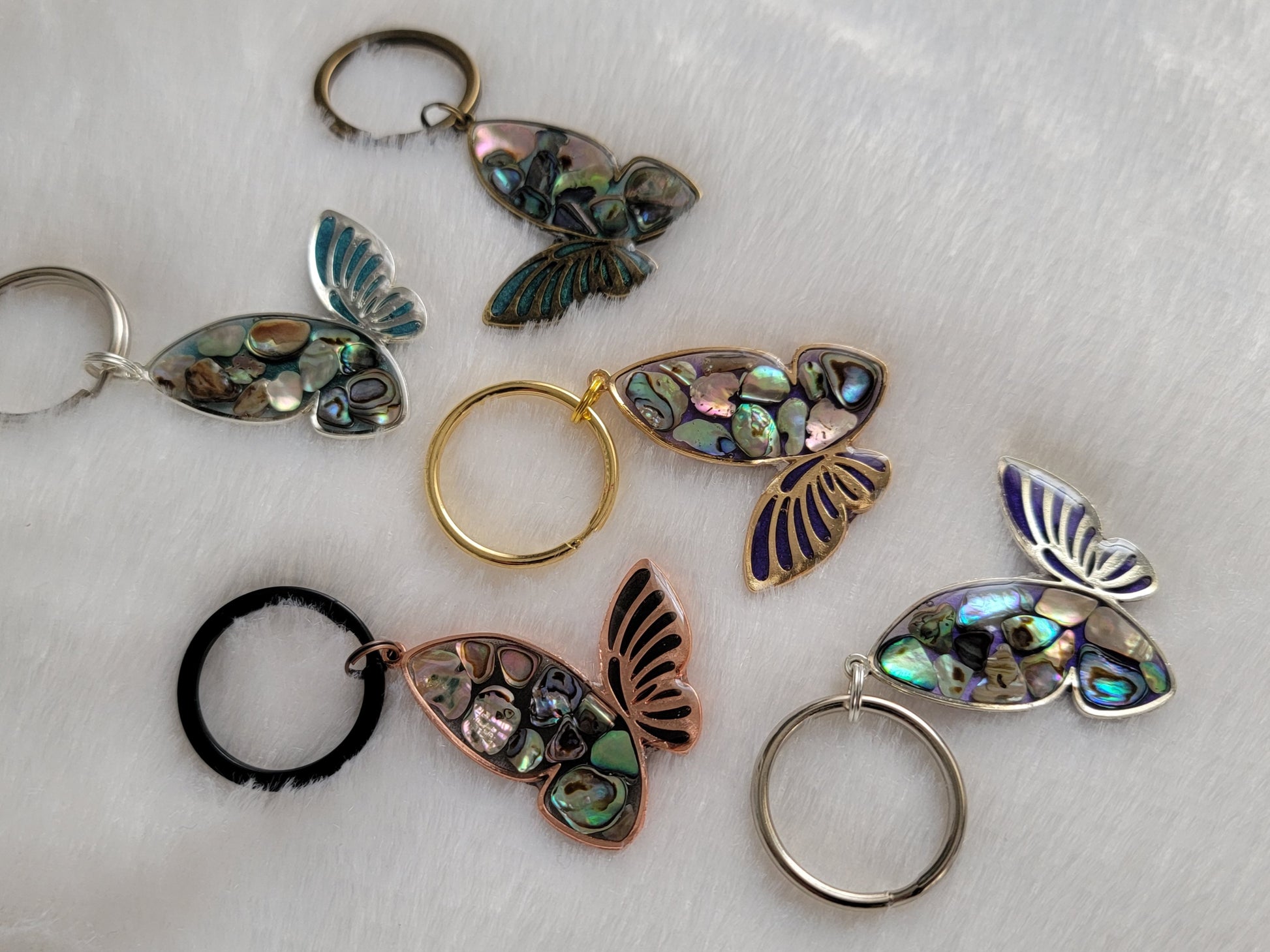 Metal butterfly charms with epoxy resin and shell filler.