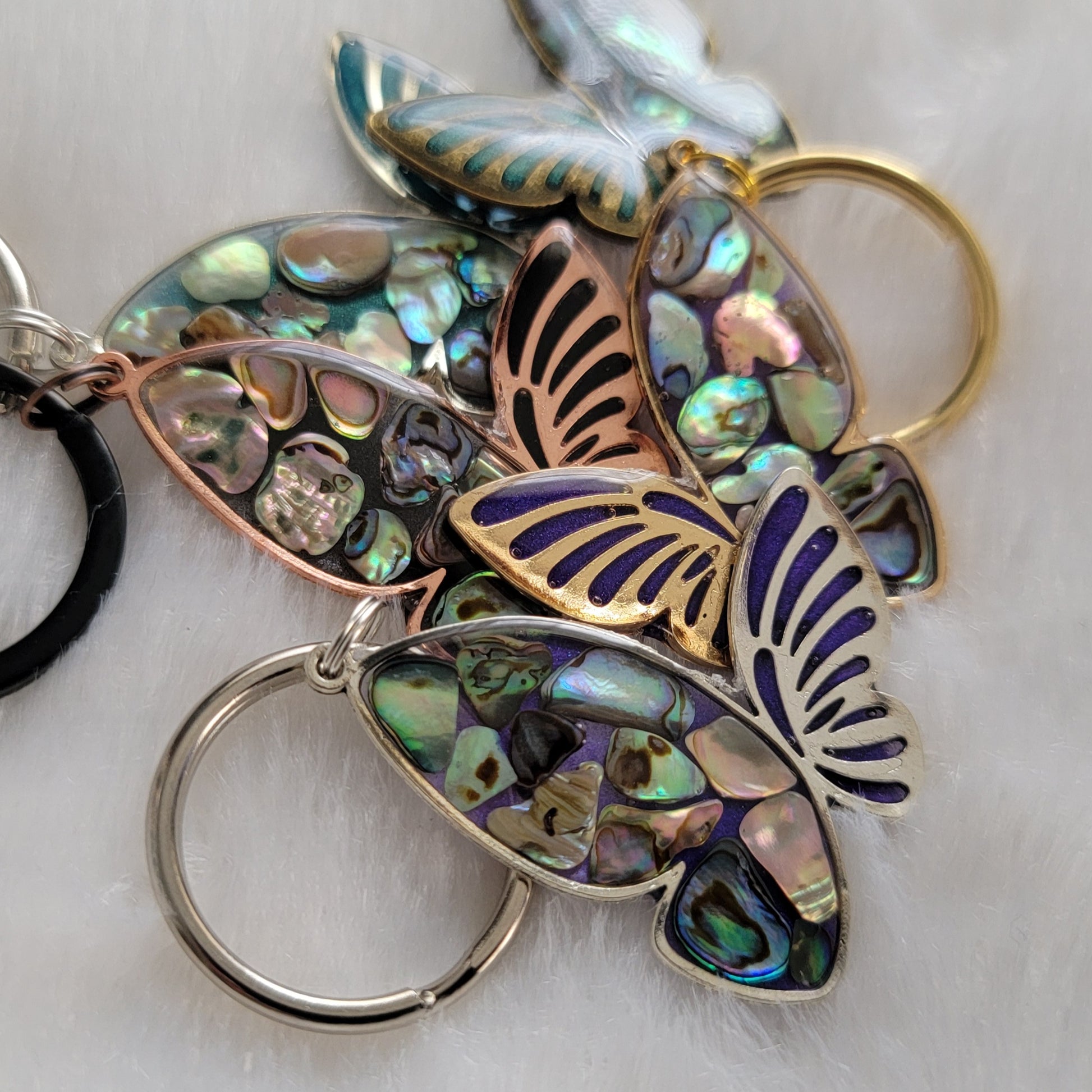 Metal butterfly charms with epoxy resin and shell filler.