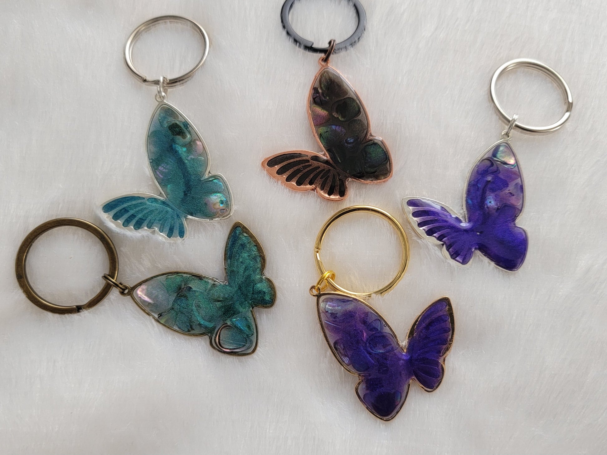 Metal butterfly charms with epoxy resin and shell filler.