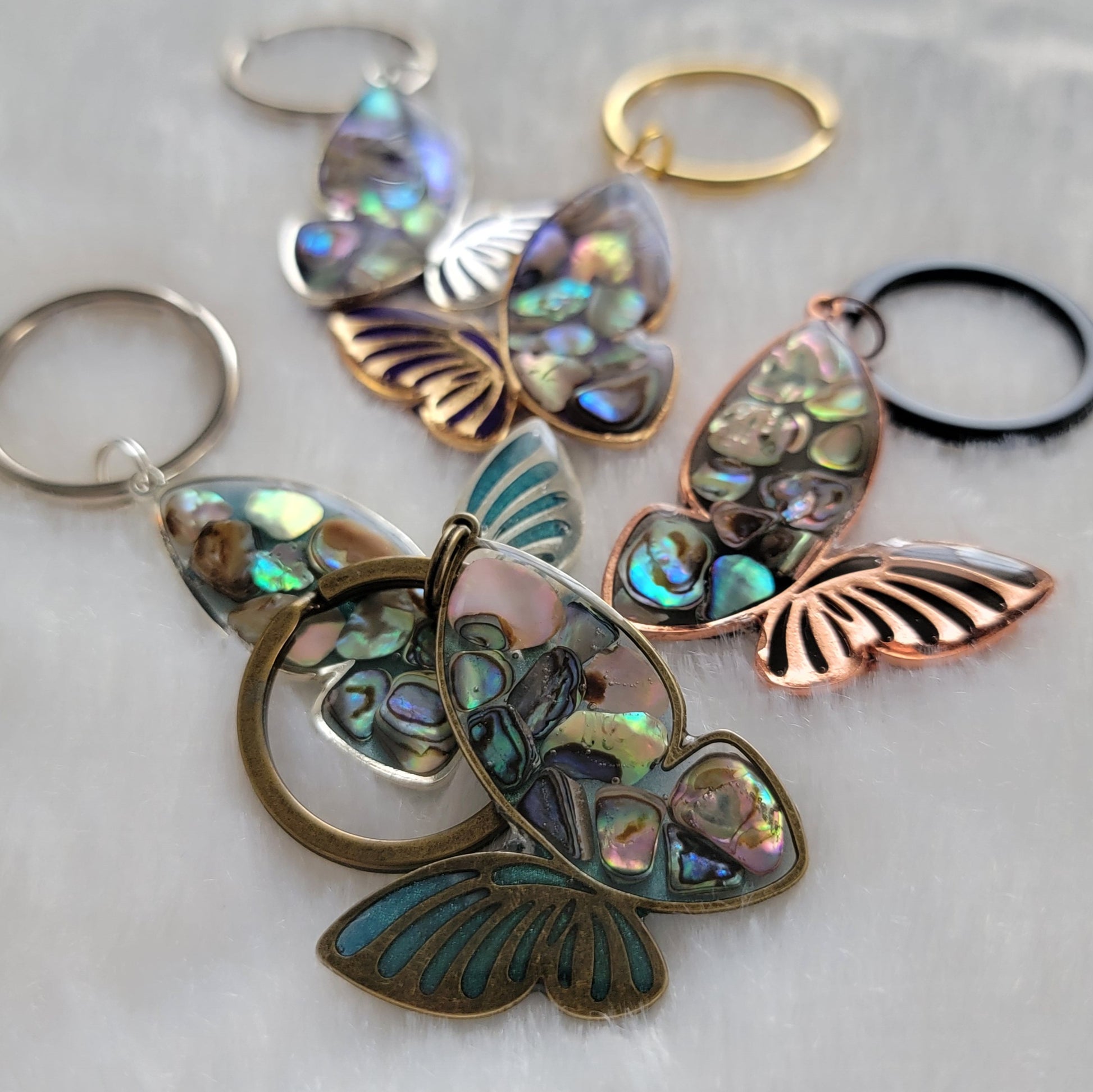 Metal butterfly charms with epoxy resin and shell filler.