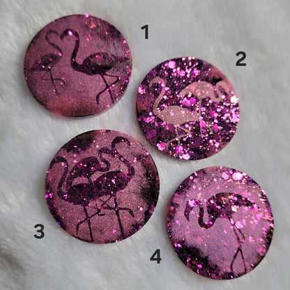 Round epoxy resin pieces, hot pink glitter with metallic flamingo designs. 