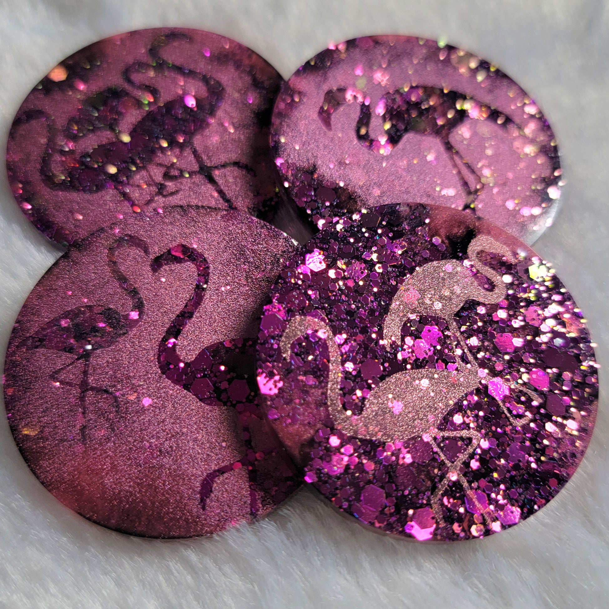 Round epoxy resin pieces, hot pink glitter with metallic flamingo designs. 