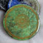 Green epoxy resin coaster with zodiac design details in gold.