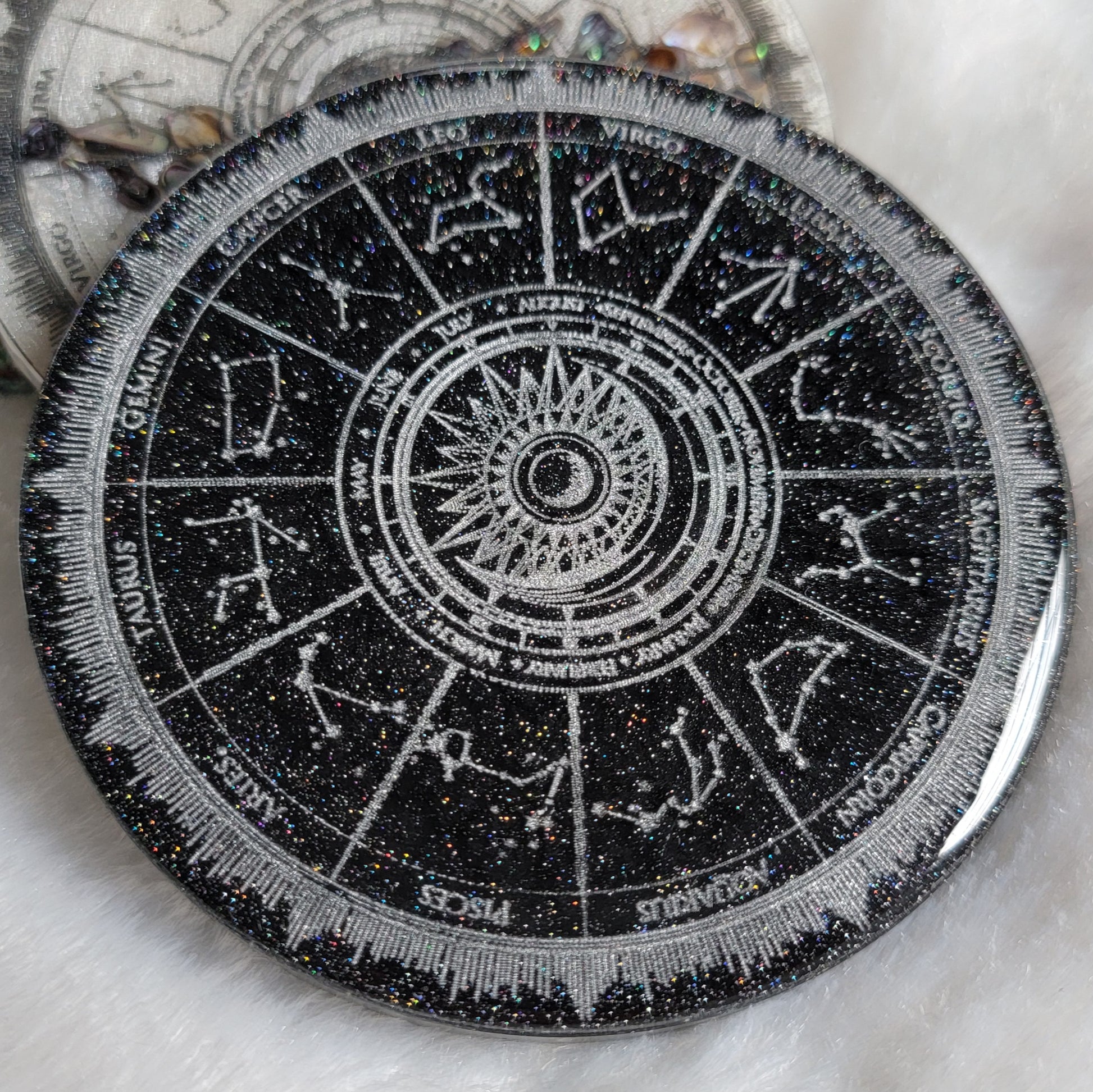 Sparkly black epoxy resin coaster with zodiac design details in silver