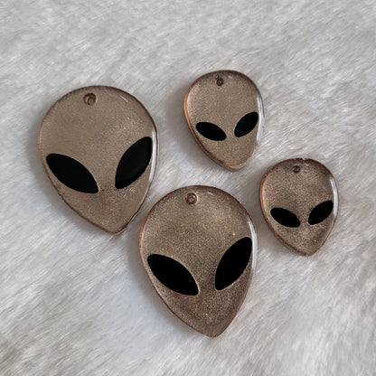 Silvery grey alien head shaped epoxy resin pieces.