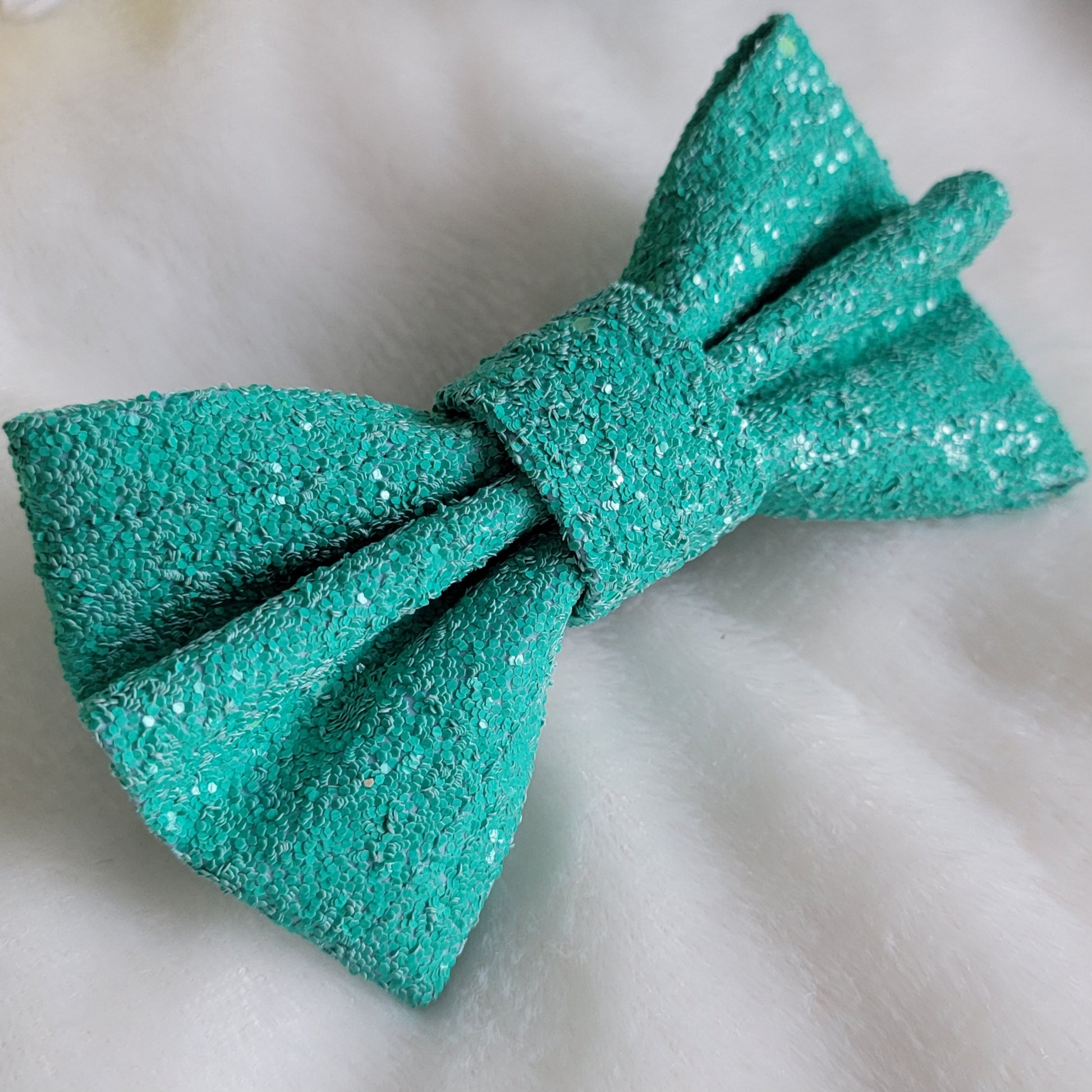 Vibrant turquoise glitter canvas bow.