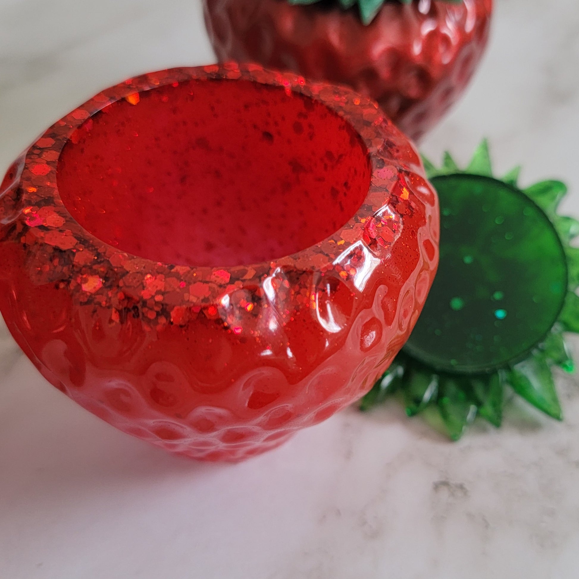 Epoxy resin trinket dishes shaped like strawberries.