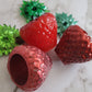 Epoxy resin trinket dishes shaped like strawberries.