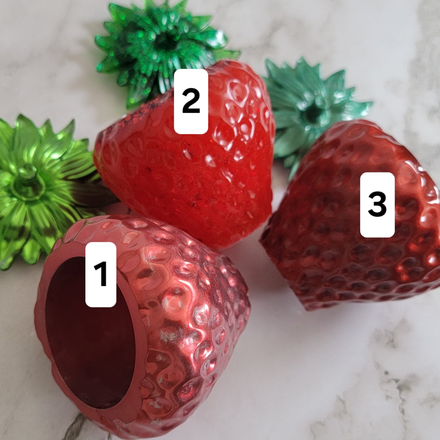 Epoxy resin trinket dishes shaped like strawberries.