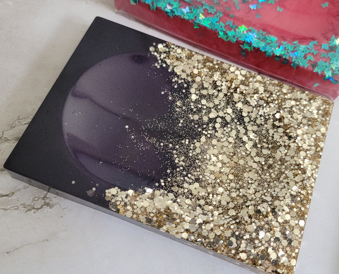 Square epoxy resin soap dish with warm silver glitter on one end fading into deep plum purple.