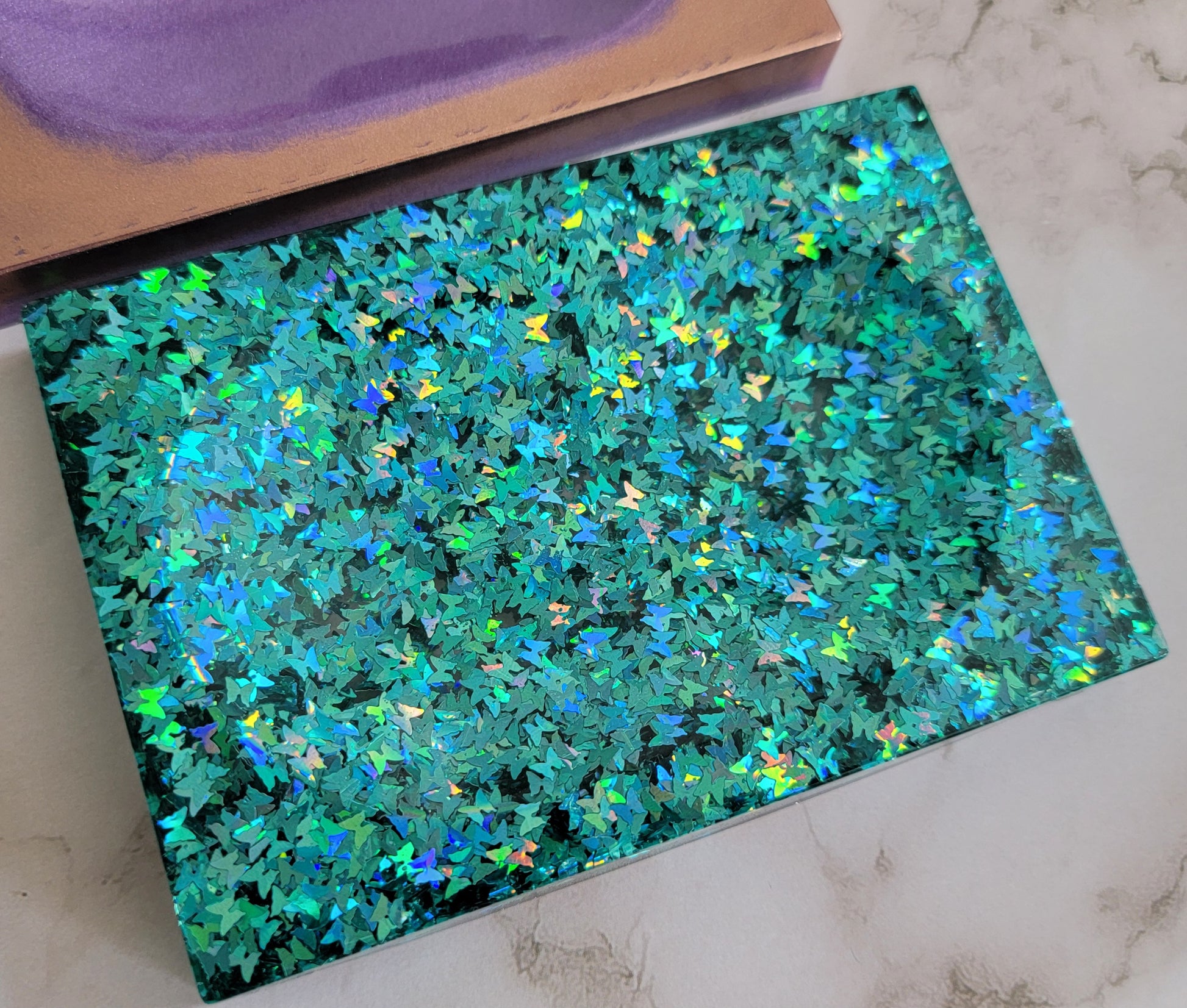 Square epoxy resin soap dish filled with blue holographic butterfly glitter.