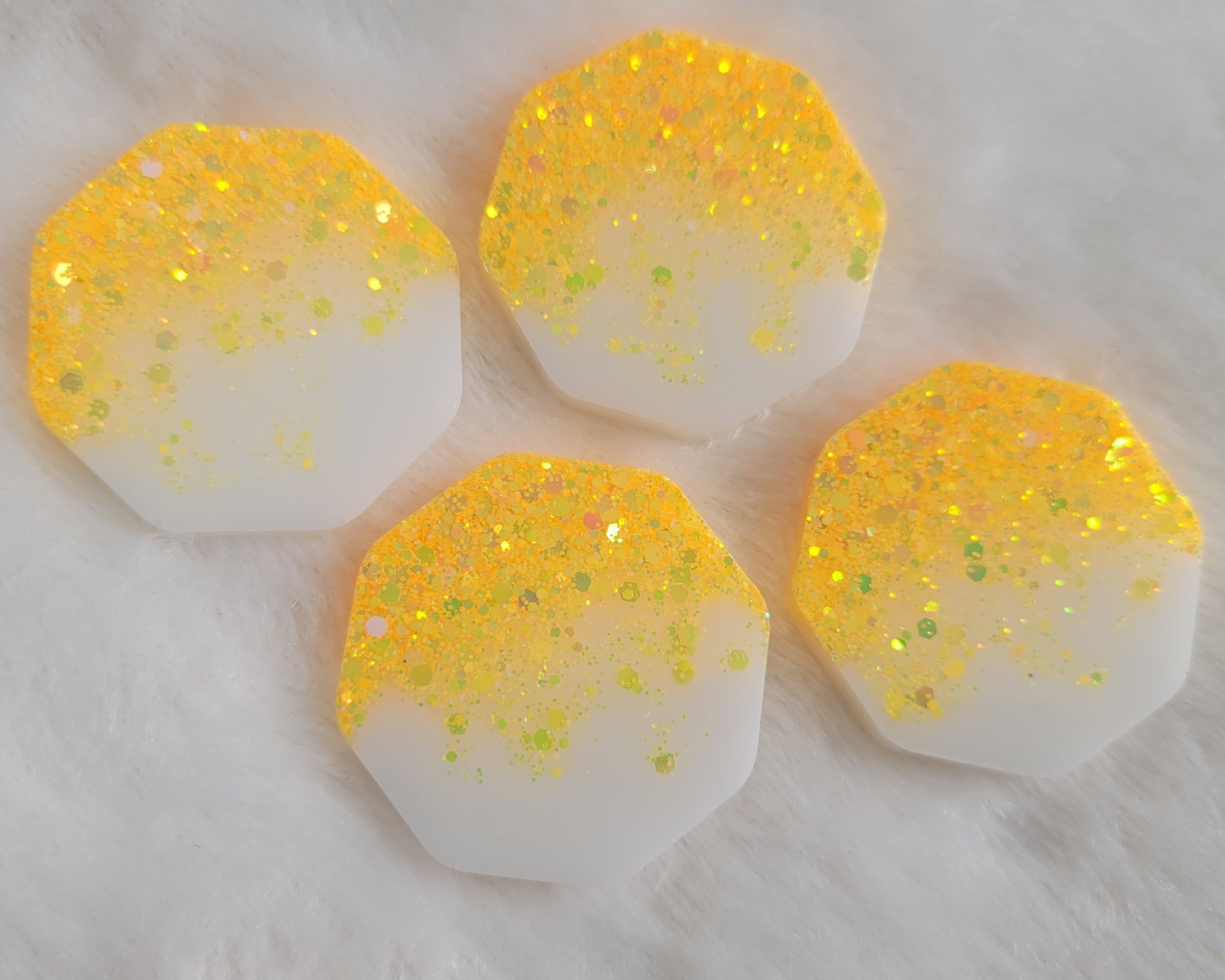 Four octagon shaped epoxy resin pieces with ultra bright yellow holographic glitter fading to opaque white pigment.