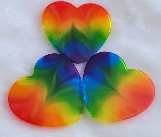 Three heart shaped epoxy resin pieces with zigzag design through translucent rainbow color stripes.