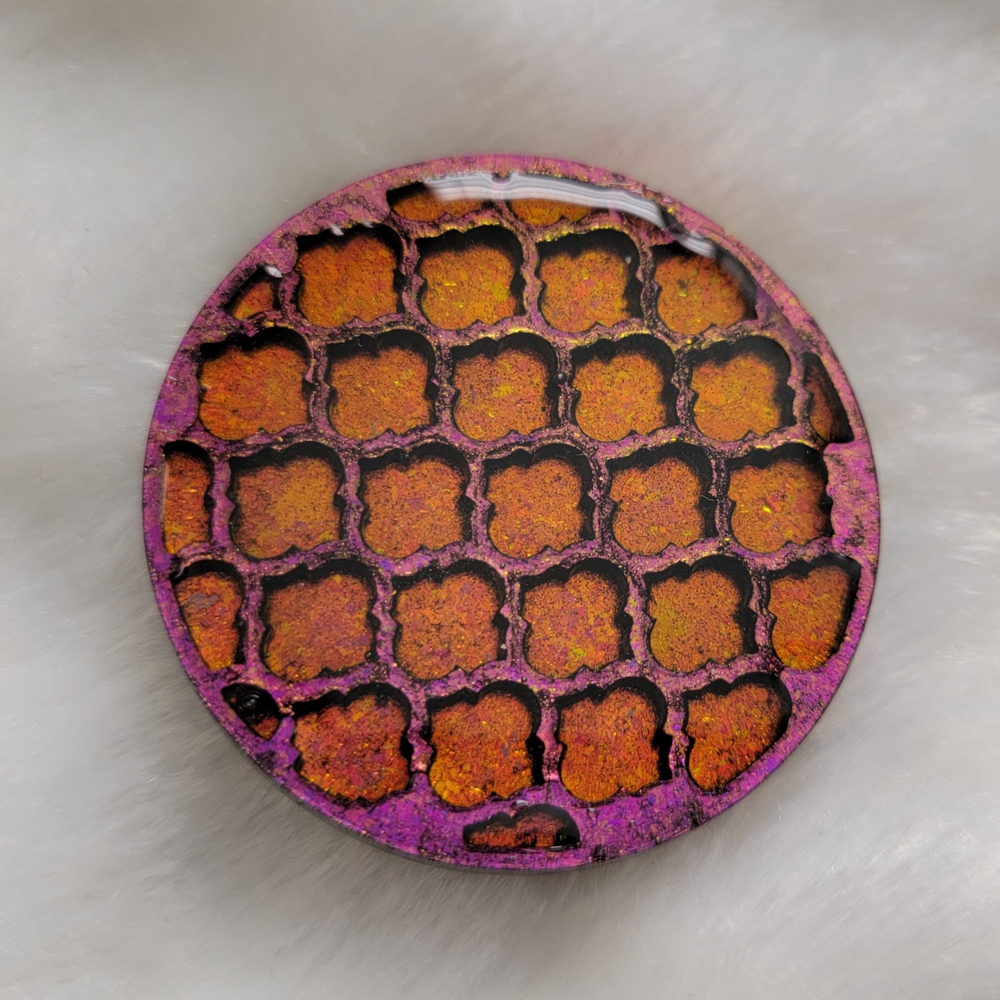 Round epoxy resin piece with three dimensional geometric tile pattern, iridescent pink/gold pigment.