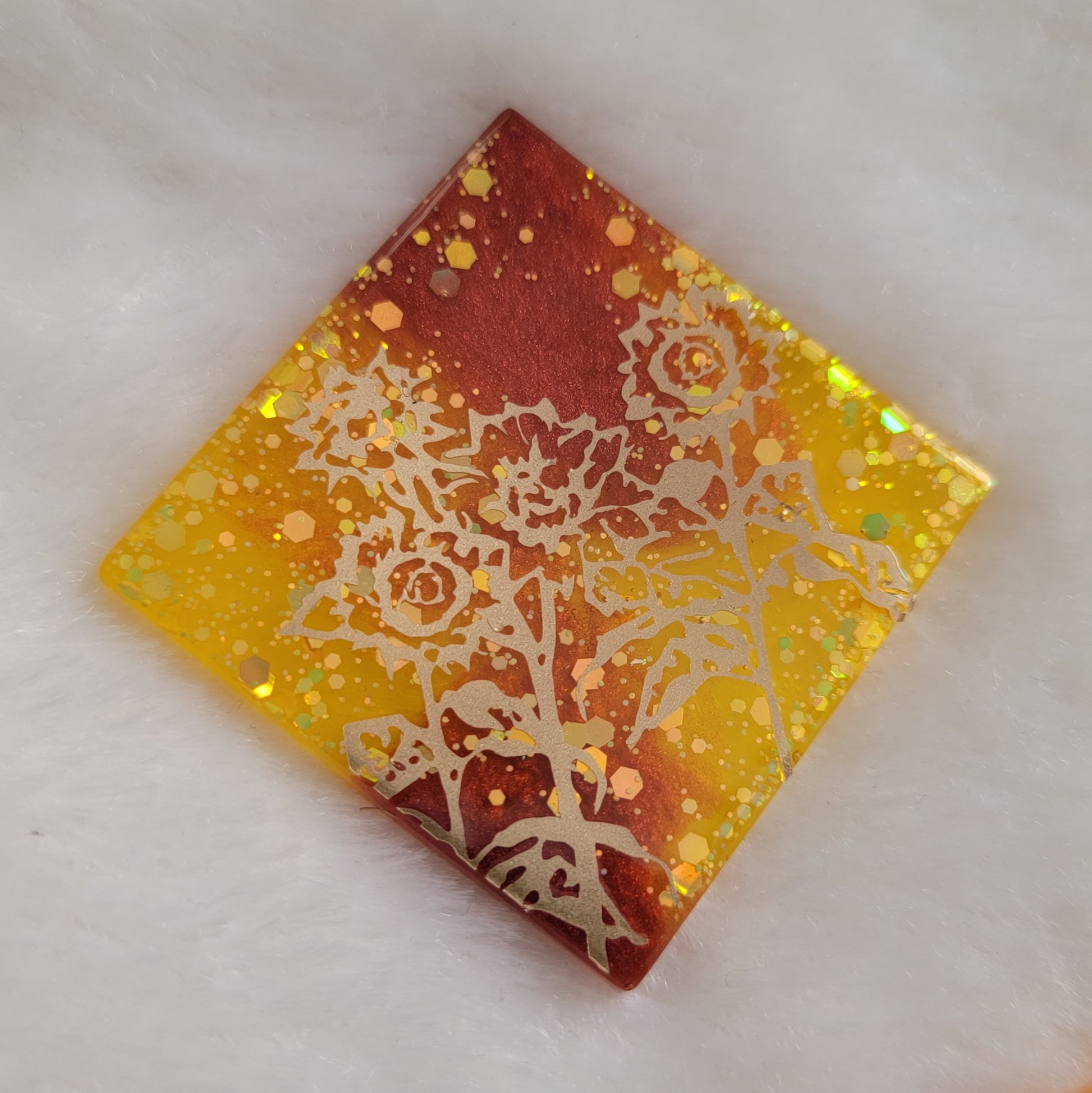 Square epoxy resin piece, yellow glitter and rust mica pigment swirls with gold vinyl sunflower design.