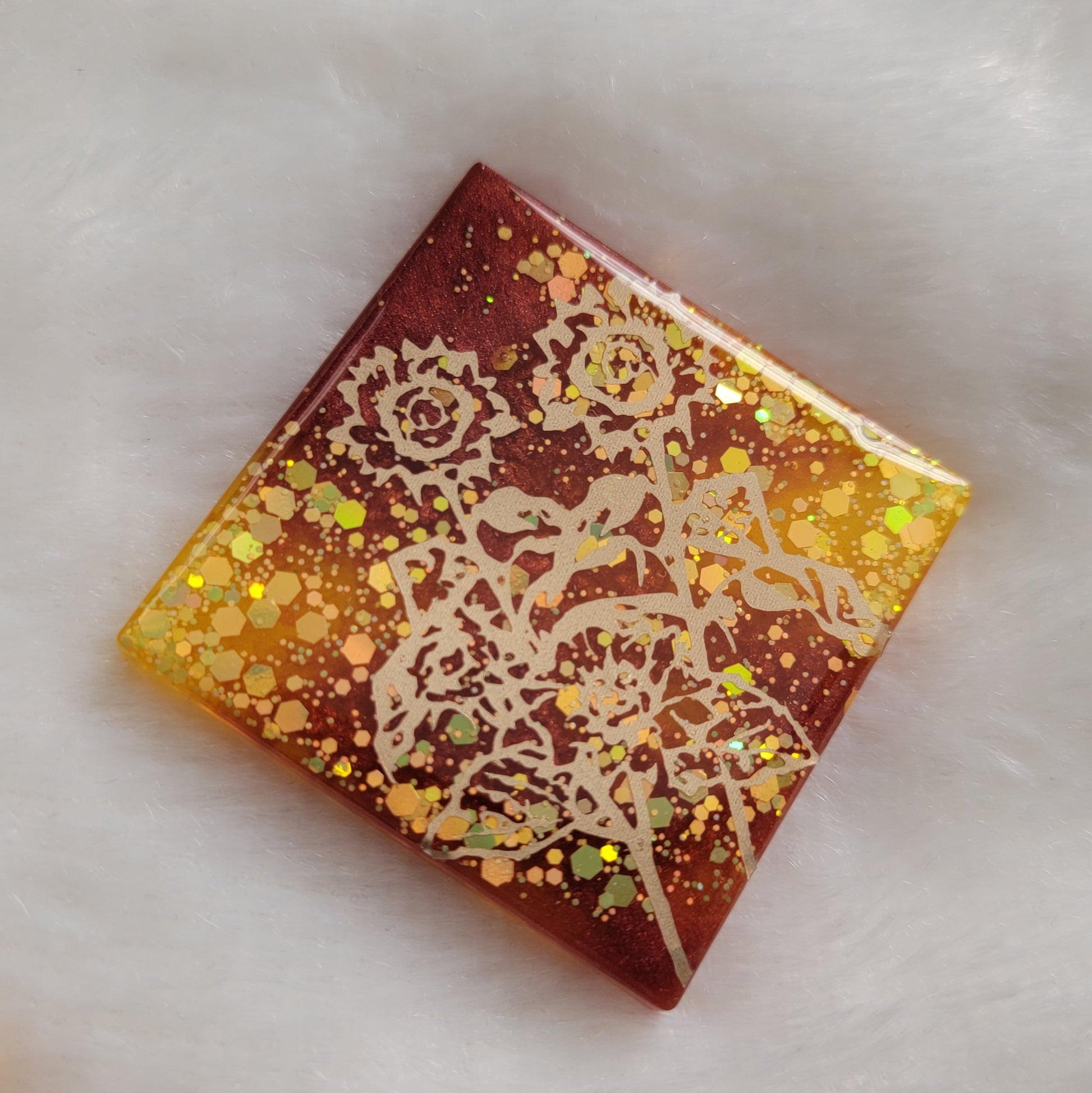 Square epoxy resin piece, yellow glitter and rust mica pigment swirls with gold vinyl sunflower design.